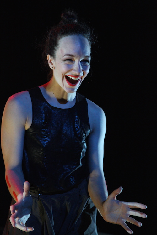 Troy Ogilvie looks expressive in a close up. Her eyes shine and her bright red lips are agape in a smile